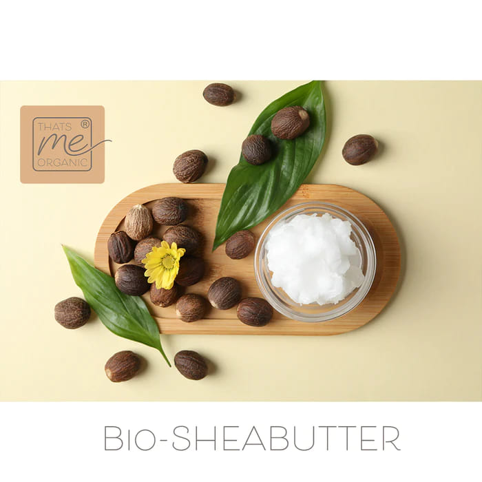 Glass bowl of organic shea butter surrounded by shea nuts and green leaves, promoting Anti Aging Lip Care Sick