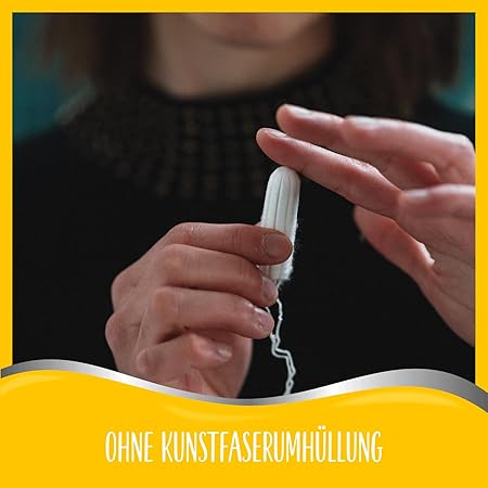 Close-up of a woman’s hands holding a Cosmea tampon, highlighting its natural composition without synthetic fiber coating.