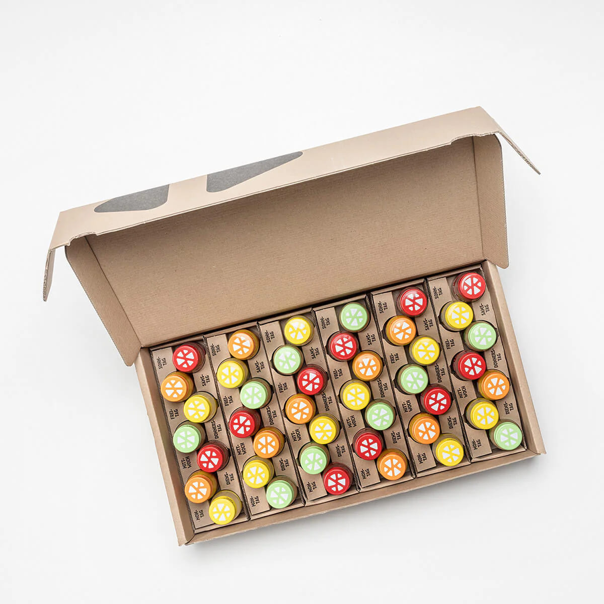 Open box showing 42 colorful Kloster Kitchen ginger shots neatly packed, with 6 vibrant cap colors