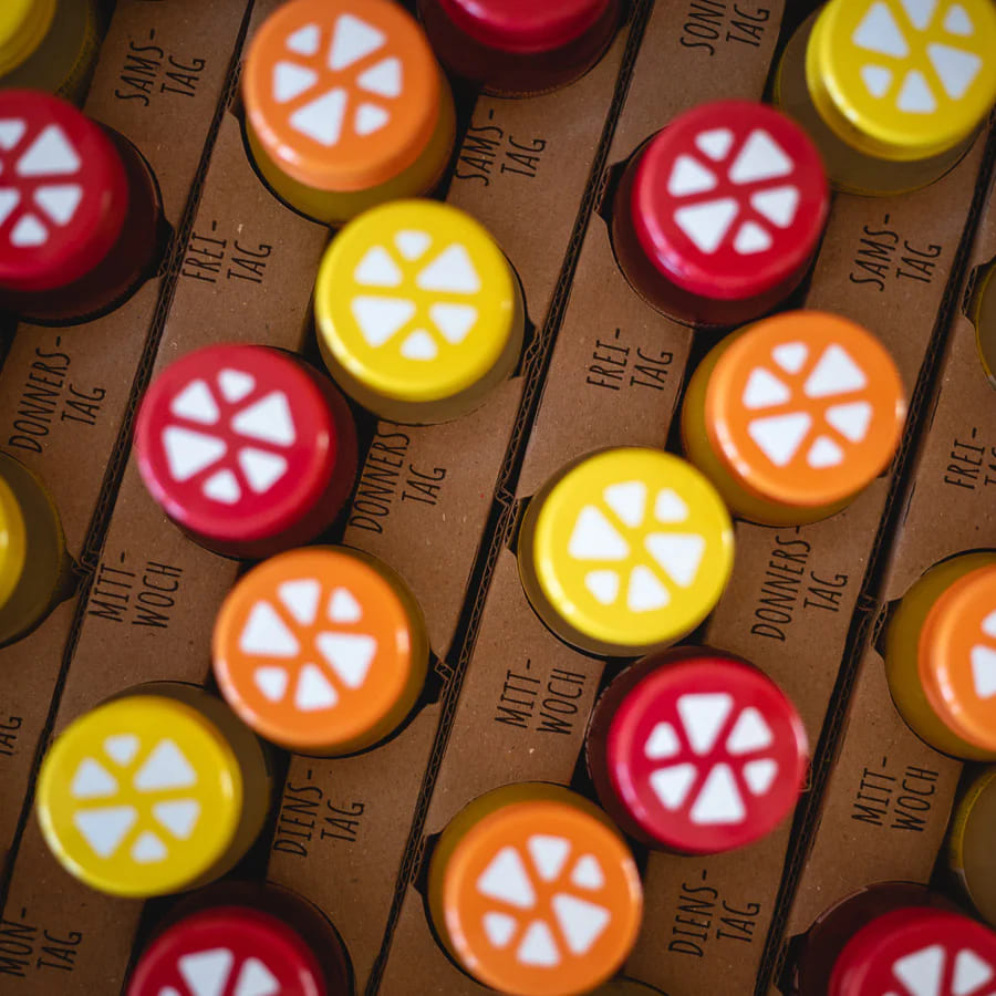 Close up of open box showing 42 colorful Kloster Kitchen ginger shots