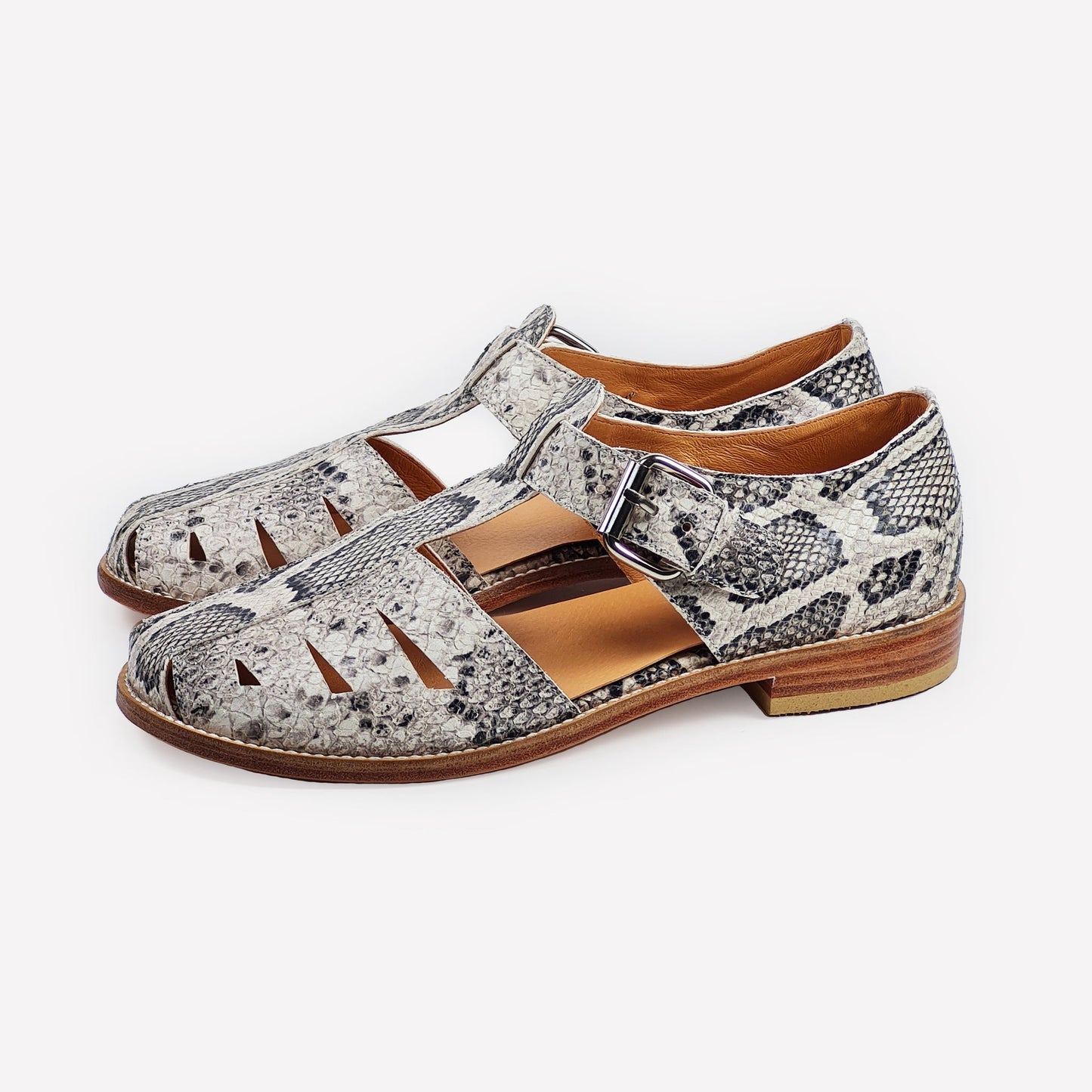 Handmade sandals with snake print, leather sole, side buckle and cut-outs. 100% leather. On a white background