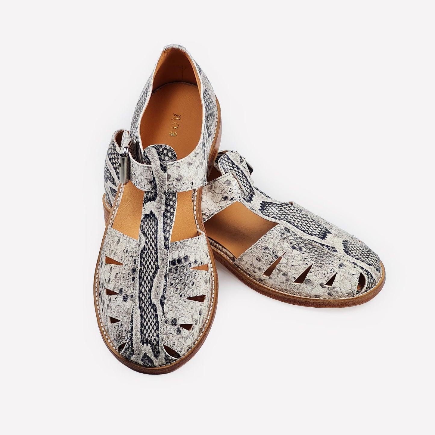 Handmade sandals with snake print, leather sole, side buckle and cut-outs. 100% leather. On a white background