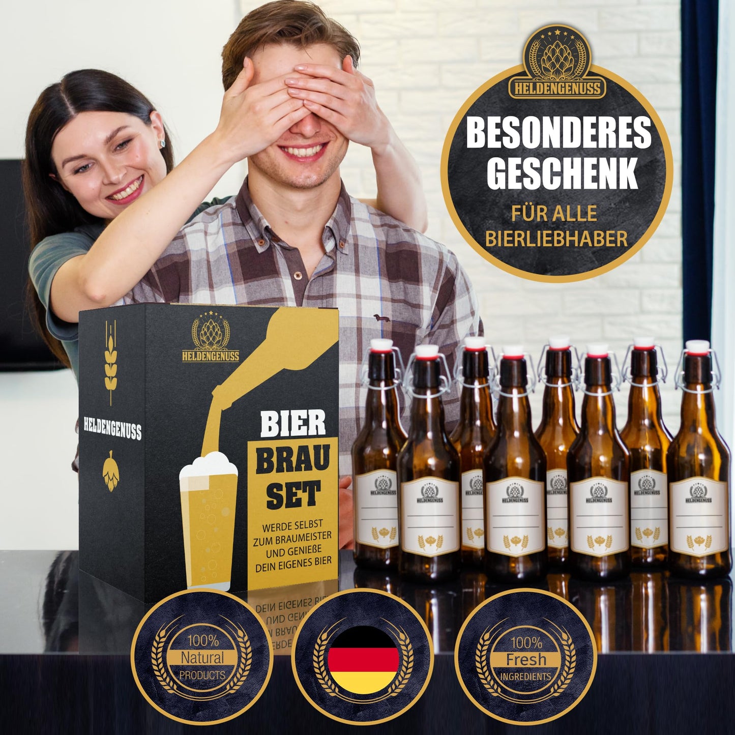 Couple with beer brewing gift set, smiling man surprised by woman, 8 filled bottles in front, labeled as natural and fresh.