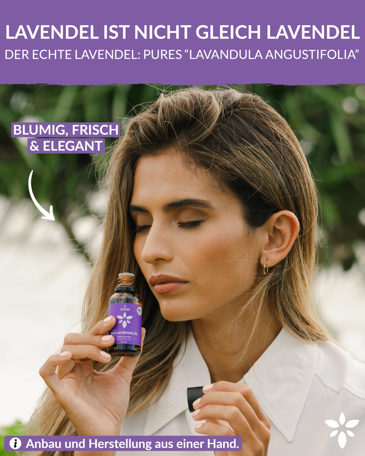 A woman holding a bottle of Heldengrun Organic Essential Oil 30ml lavendel