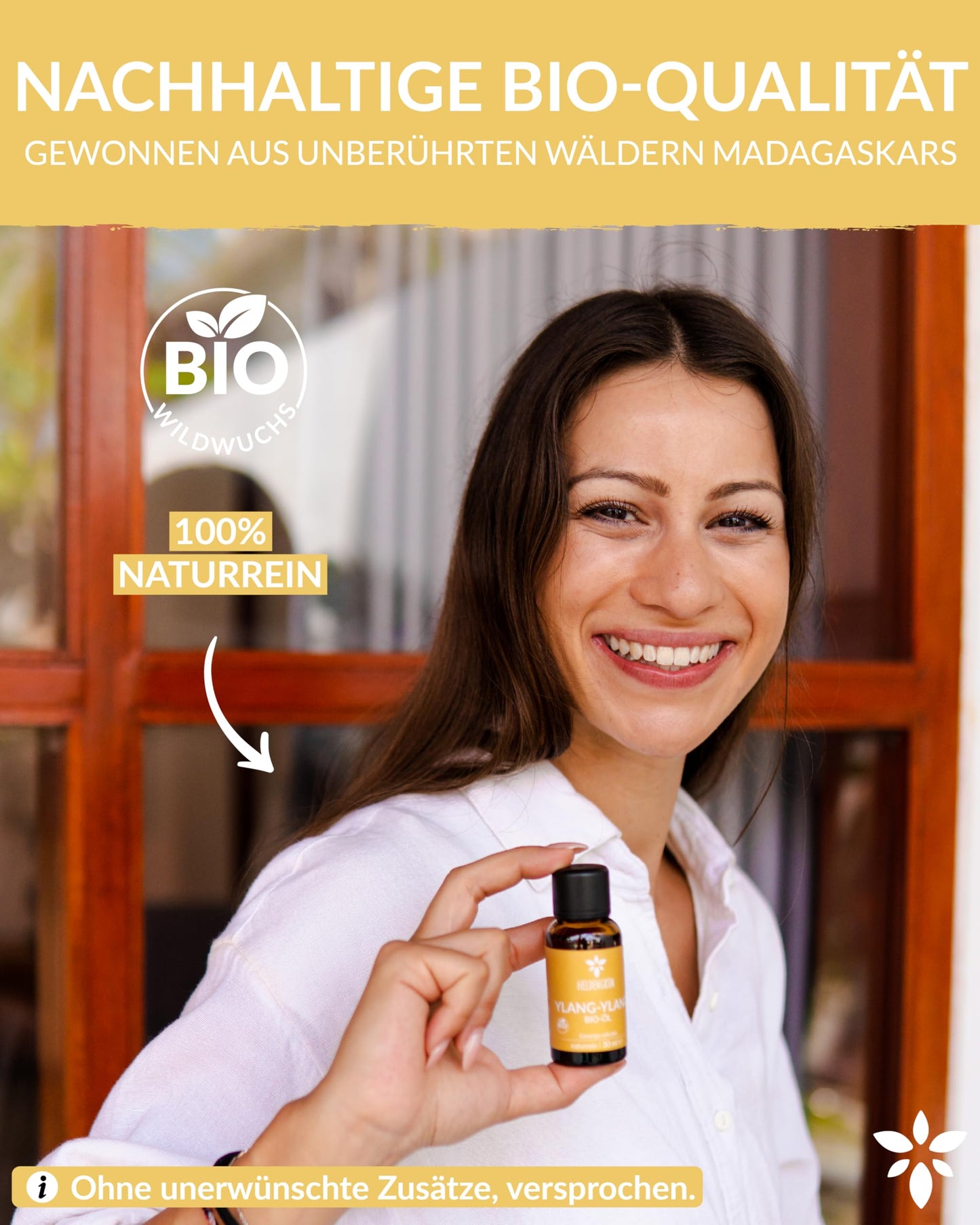A woman holding a bottle of Heldengrun Organic Essential Oil 30ml ylang-ylang