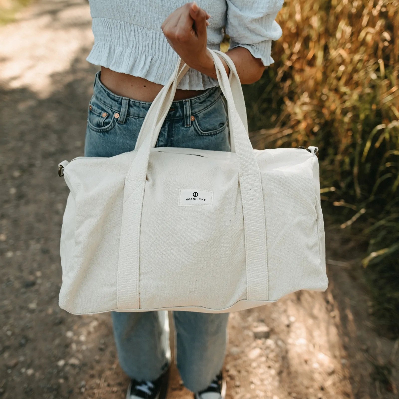 Nordlicht organic cotton travel bag carried outdoors, eco-friendly and perfect for weekend or nature getaways