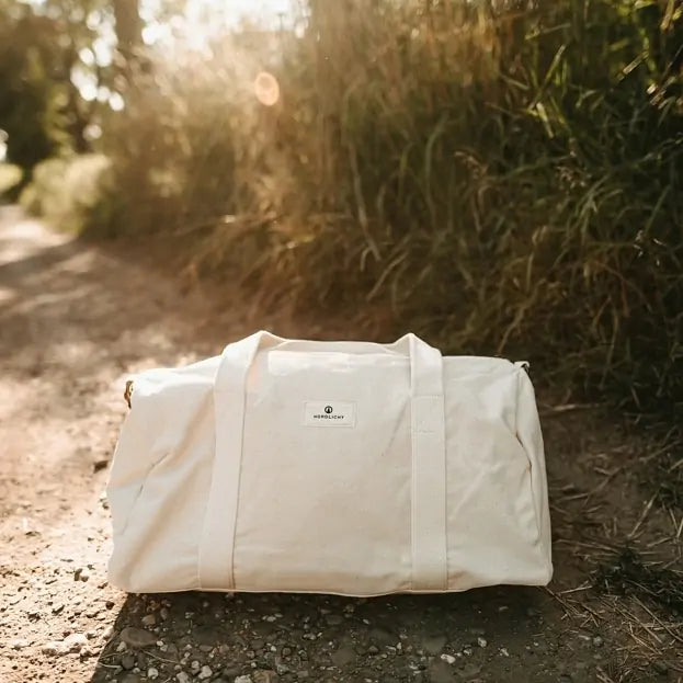 Nordlicht organic cotton travel bag resting on a sunlit forest path, ideal for eco-conscious outdoor getaways