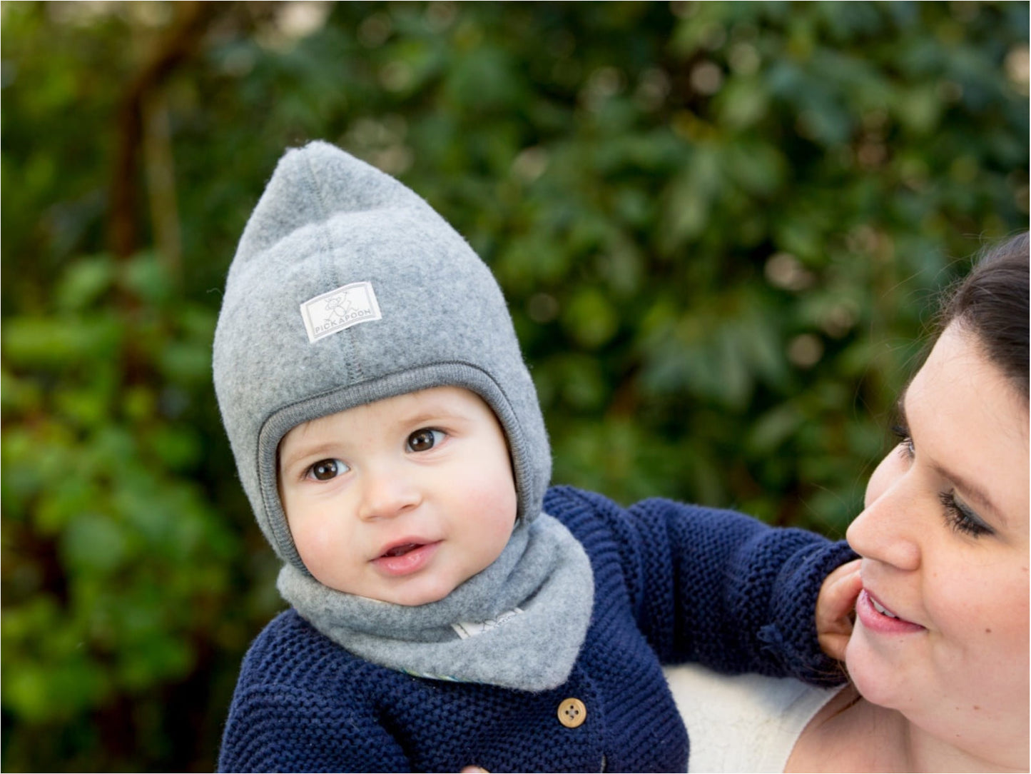 Baby wearing Pickapooh triangular scarf for babies and children, made from soft organic wool. In mother's arm
