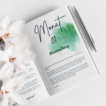 Open German journal "Planet Positiv" with flowers and pen by Green Cloud Nine