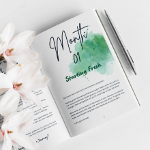 Open English journal "Planet Positive" with flowers and pen by Green Cloud Nine