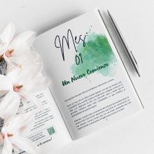 Open Spanish journal "Planeta en Positivo" with flowers and pen by Green Cloud Nine