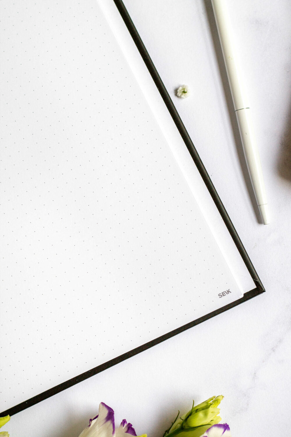 Close-up of an open Eco-friendly Refillable Notebook. On a white surface