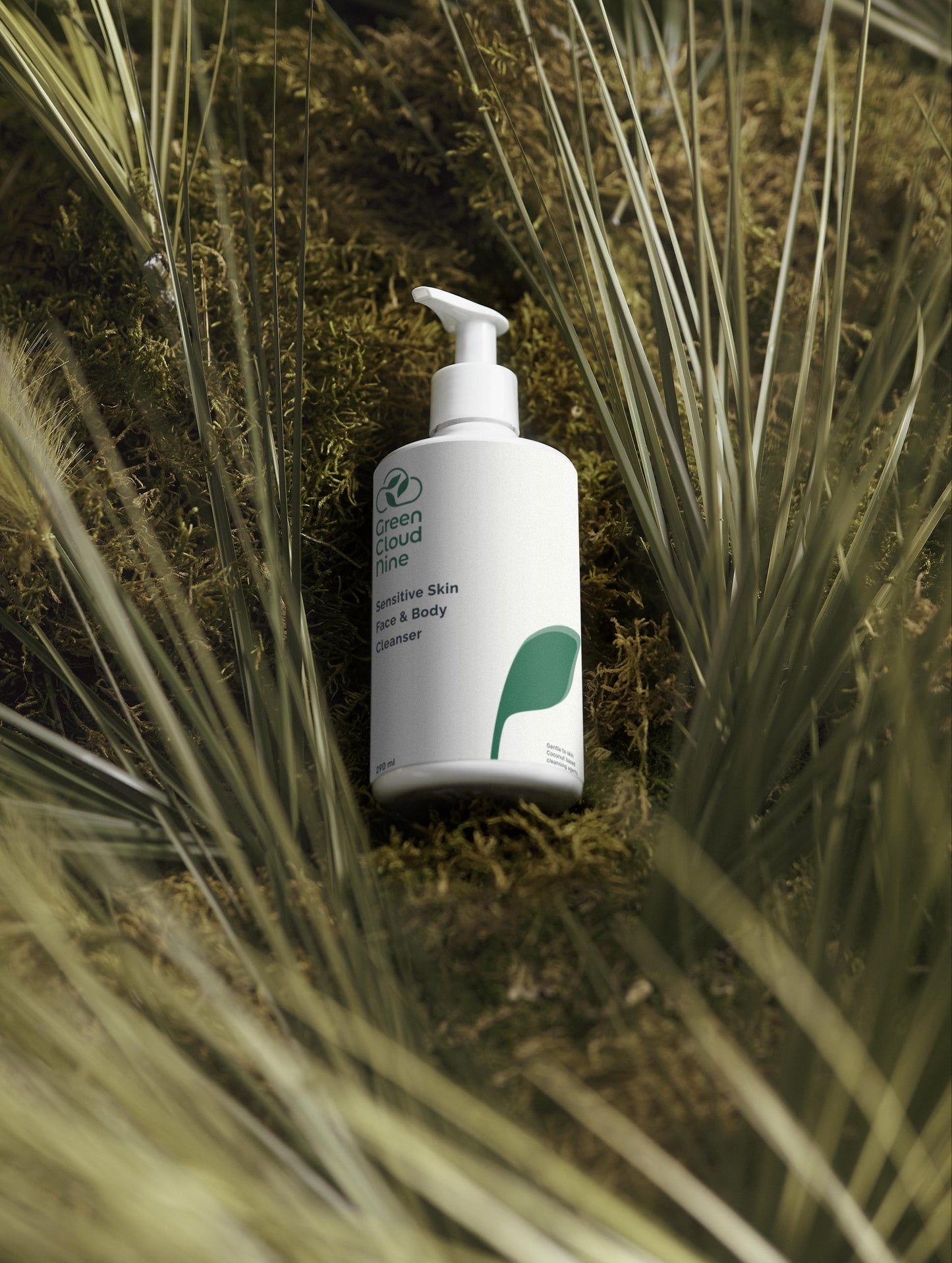 Green Cloud Nine Sensitive Skin Face & Body Cleanser lying on a moos and grass bed