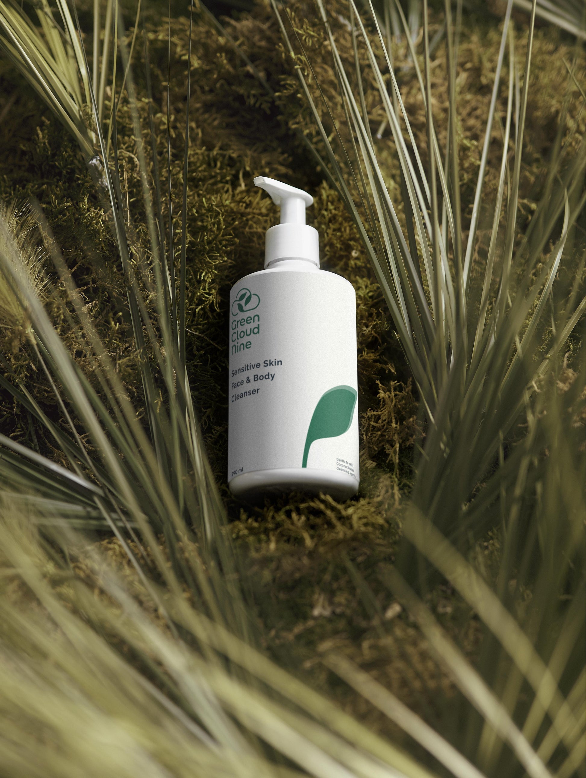 Green Cloud Nine Sensitive Skin Face & Body Cleanser lying on a moos and grass bed
