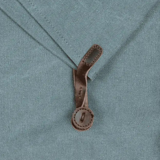 Close-up of Turquoise canvas and leather handbag with adjustable straps and a loop closure, eco-friendly and handmade.