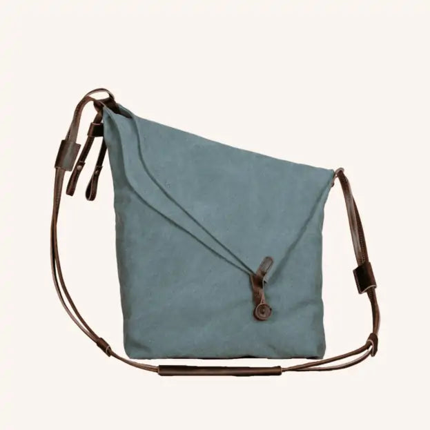 Turquoise canvas and leather handbag with adjustable straps and a loop closure, eco-friendly and handmade.
