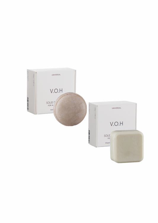 V.O.H solid hair conditioner and solid shampoo bars with their minimalist white packaging on a plain background.