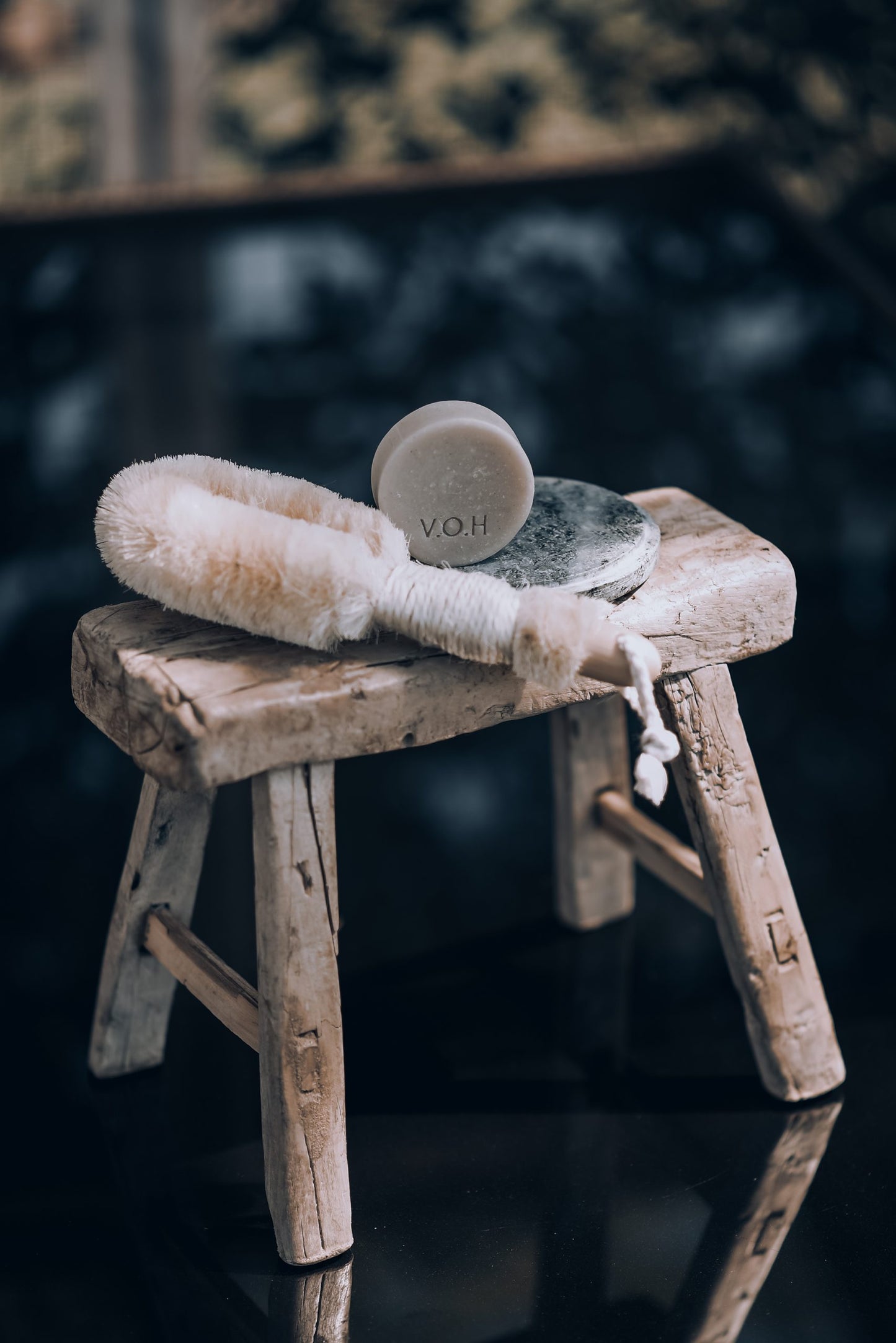 V.O.H solid hair conditioner and solid shampoo bars on a little chair with a brush