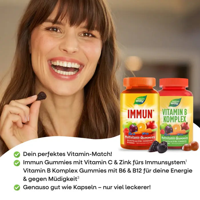 Smiling woman holding a gummy next to Nature’s Way Immun & Vitamin B Komplex bottles—your tasty daily vitamin match.