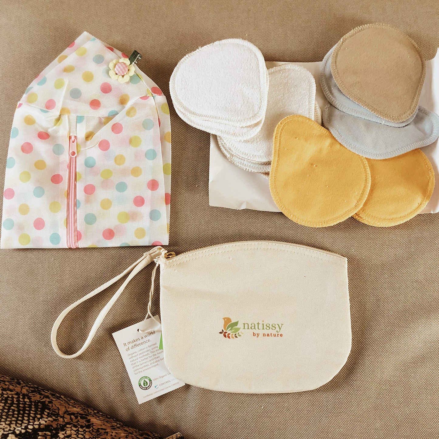 Washable Organic Cotton panty liners with wings lying on a beige bed