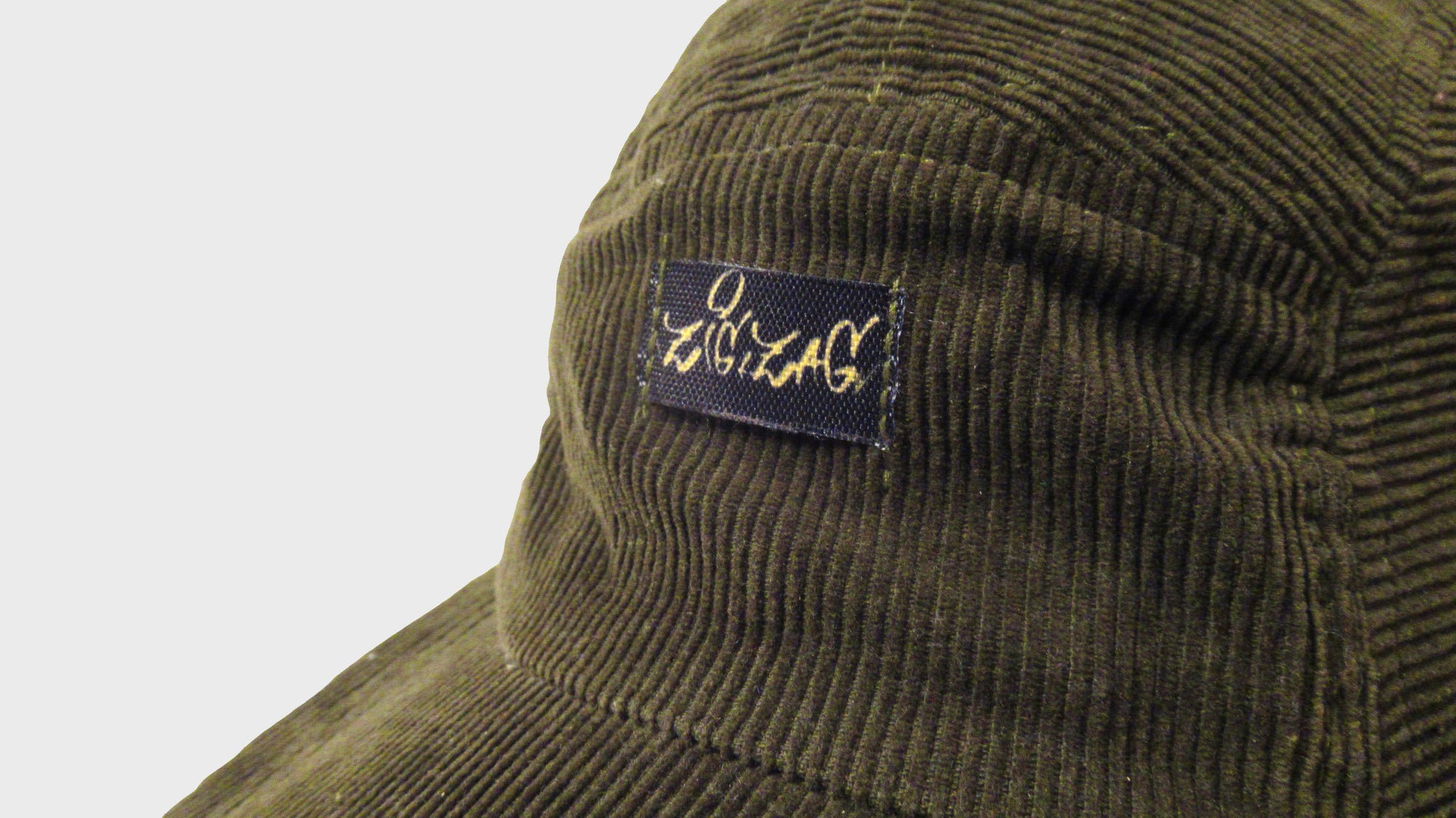 Zig Zag upcycled green army cap. made from repurposed textiles, combining sustainability, durability, and style for an eco-friendly fashion choice
