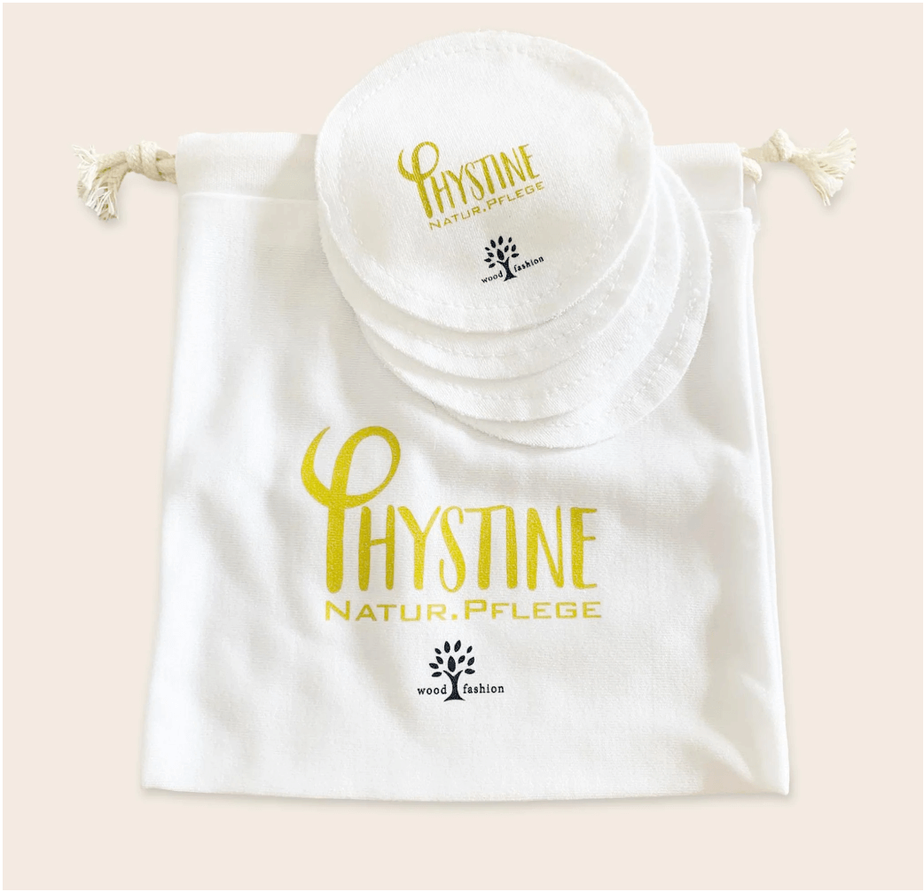 White round Phystine cleansing pad with gold/blue logo on neutral background and bag