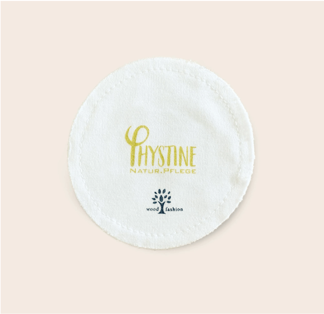 White round Phystine cleansing pad with gold/blue logo on neutral background