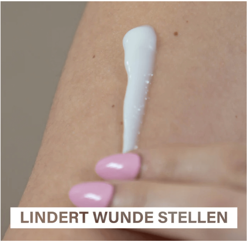 A hand with pink nails applying Rosental Mommy & Baby Balm on the skin to relieve sore and irritated areas.