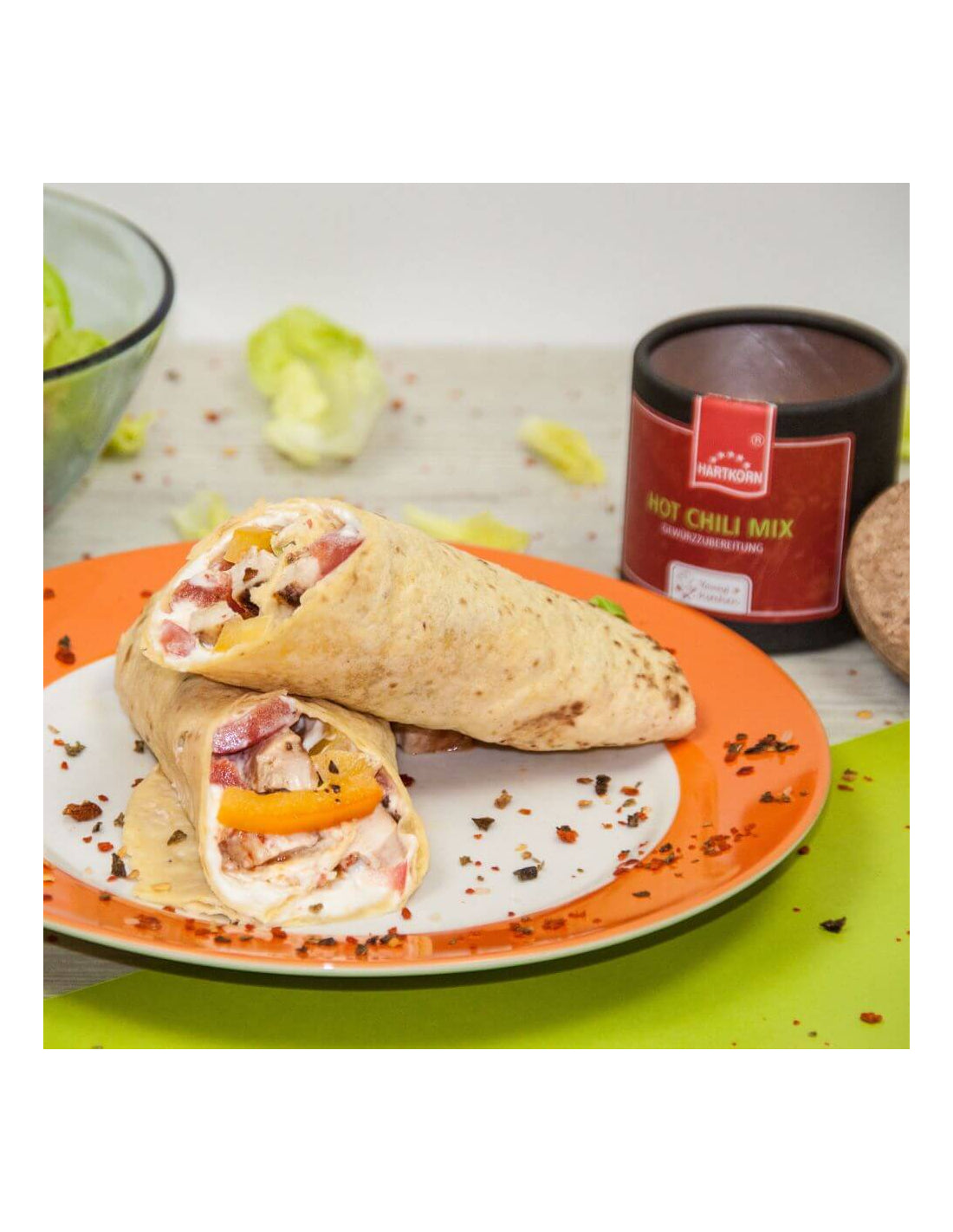 Spicy wraps on a plate with chili flakes, paired with Hot Chili Mix jar for a bold, fiery flavor boost in every bite.