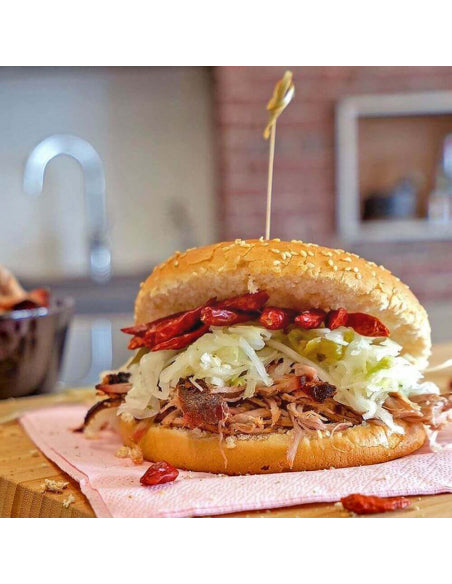 Pulled pork burger with slaw and chilies on a sesame bun smoky, spicy, and mouthwatering