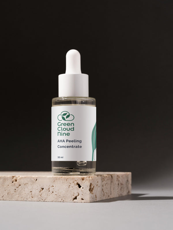 Green Cloud Nine AHA Peeling Concentrate, elegantly placed on a marble surface against a dark background