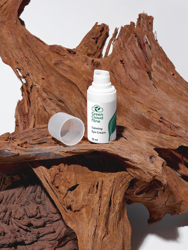Green Cloud Nine Calming Eye Cream standing on drifted wood 