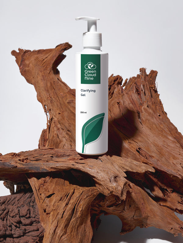 Green Cloud Nine Clarifying Gel standing on drifted wood 