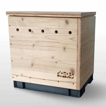 Wooden worm composting box on a grey plastic base, with ventilation holes and Wurmkiste branding on the front panel