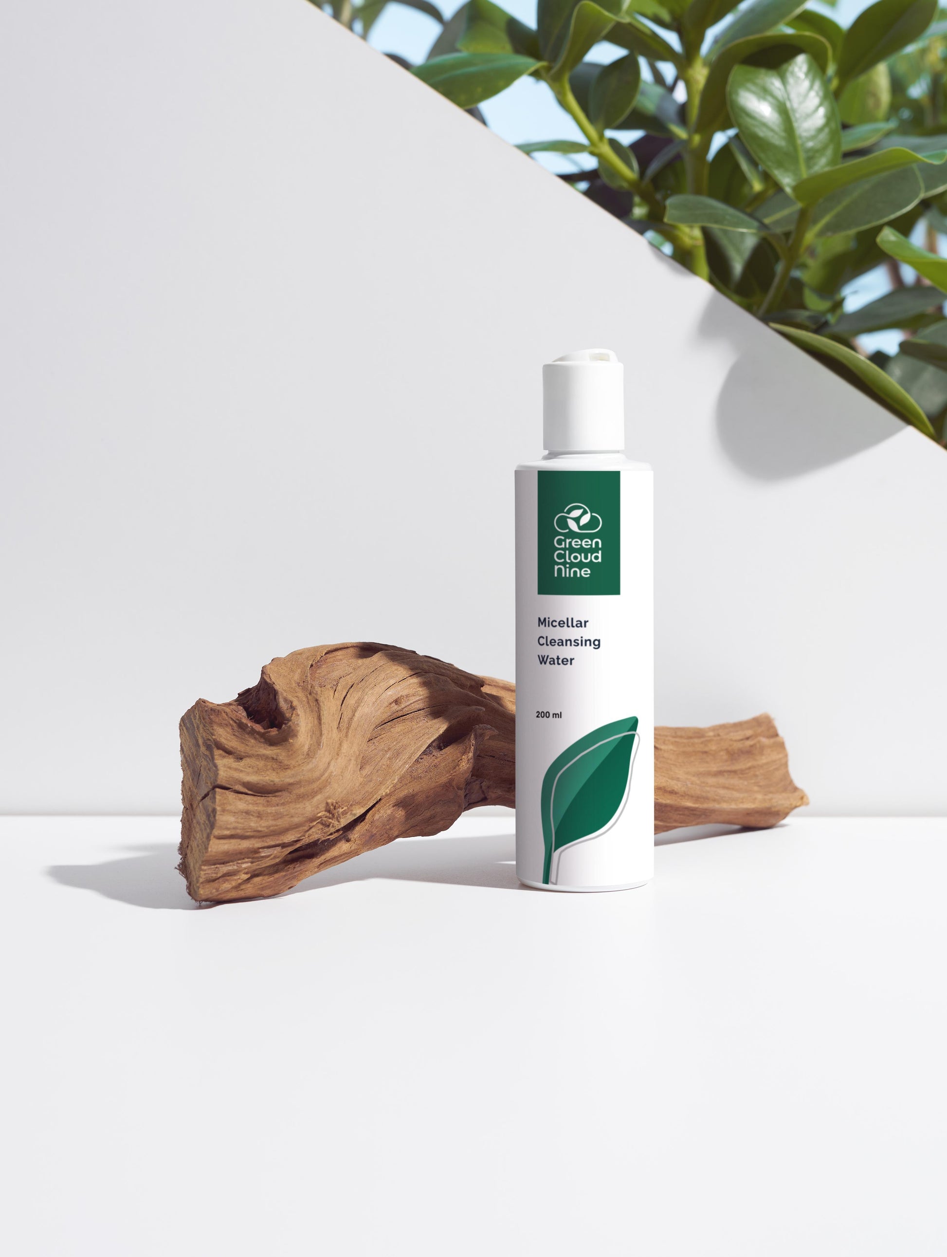 Micellar Cleansing Water with Green Cloud Nine logo. White pump on a white background with plants and wood