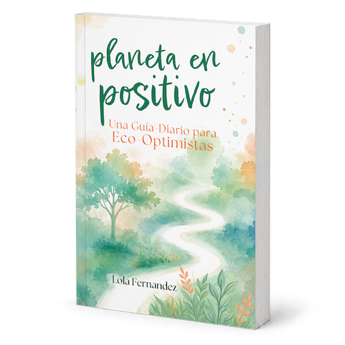 A Spanish-language book titled "planeta en positivo" by Lola Fernandez, shown standing upright against a clean white background. The cover features a watercolor landscape with a winding white path through green and teal foliage, with orange and green text.