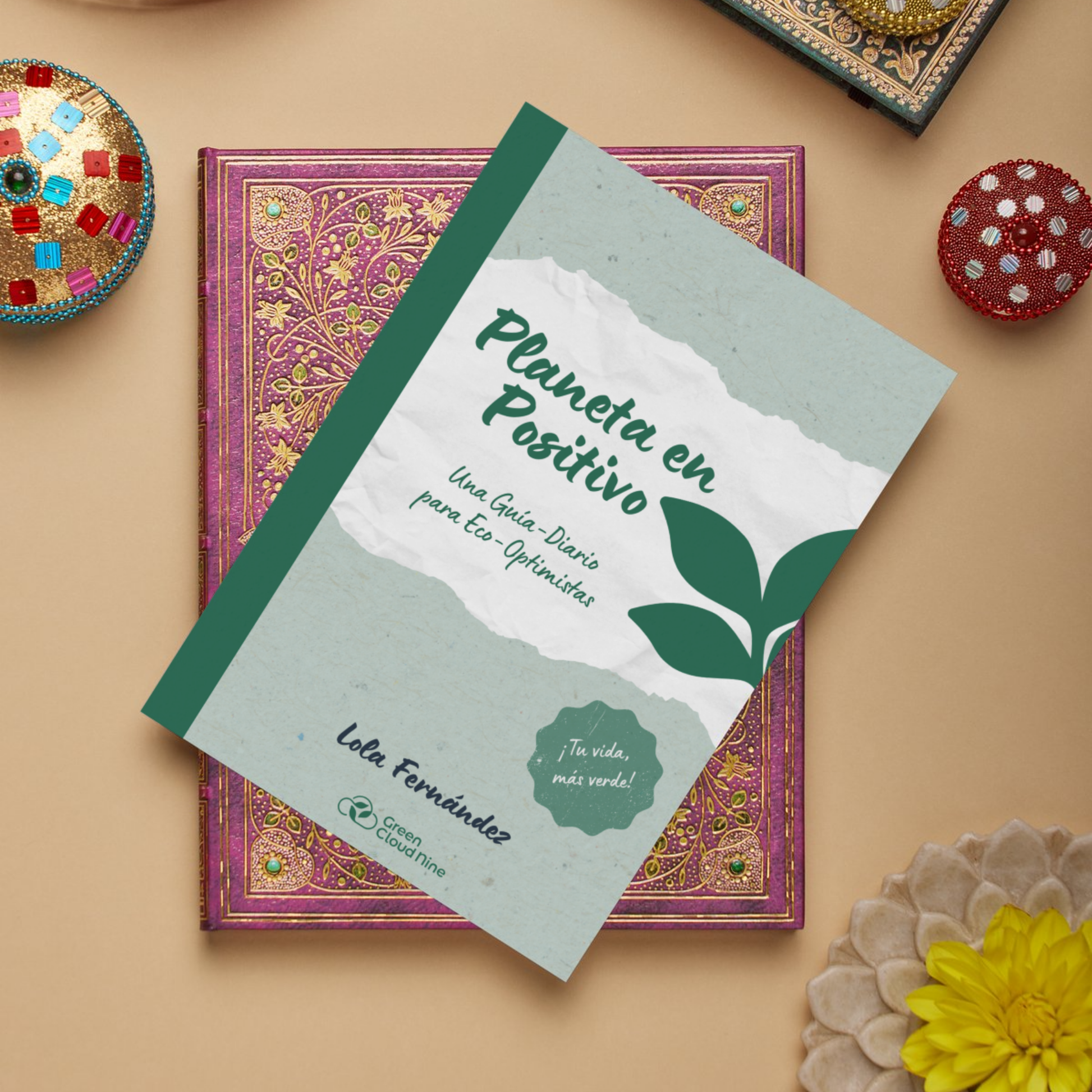 Cover of “Planeta en Positivo” (Spanish) eco-journal by Lola Fernández, placed on decorative books with ethnic pattern