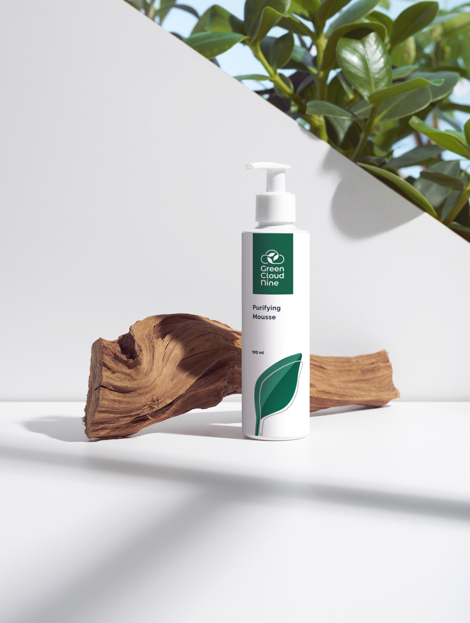 Purifying Mousse with Green Cloud Nine logo. White pump on a white background with plants and wood