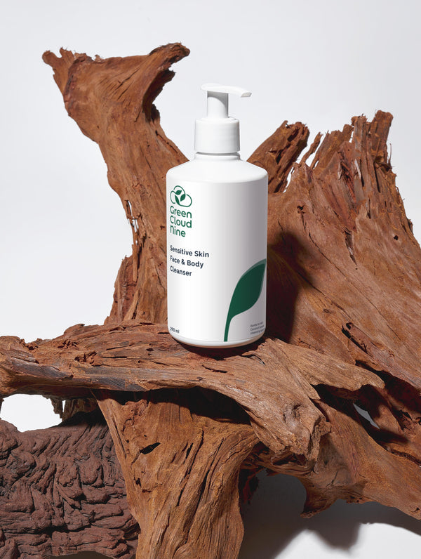 Green Cloud Nine Sensitive Skin Face & Body Cleanser standing on drifted wood