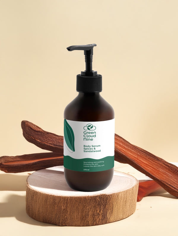 Body serum spices & sandalwood in brown pump bottle with white label, displayed on wood base with sandalwood sticks.