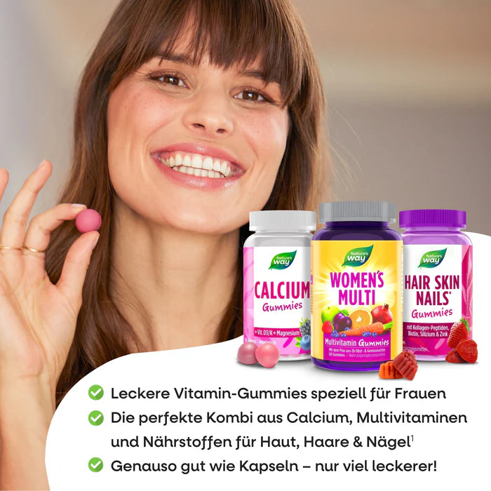 Smiling woman holding a gummy, with Calcium, Women’s Multi, and Hair Skin Nails supplements by Nature’s Way in the foreground